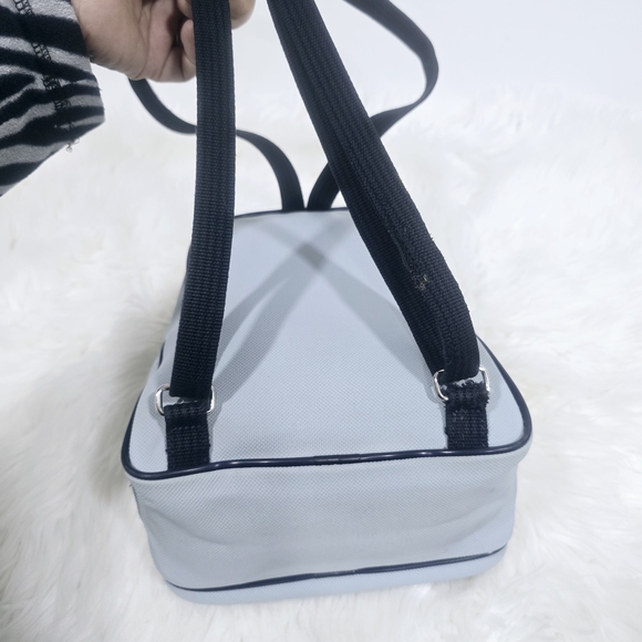 Lacoste mini backpack in a soft light blue shade with navy blue trim accents. - Picture 11 of 16